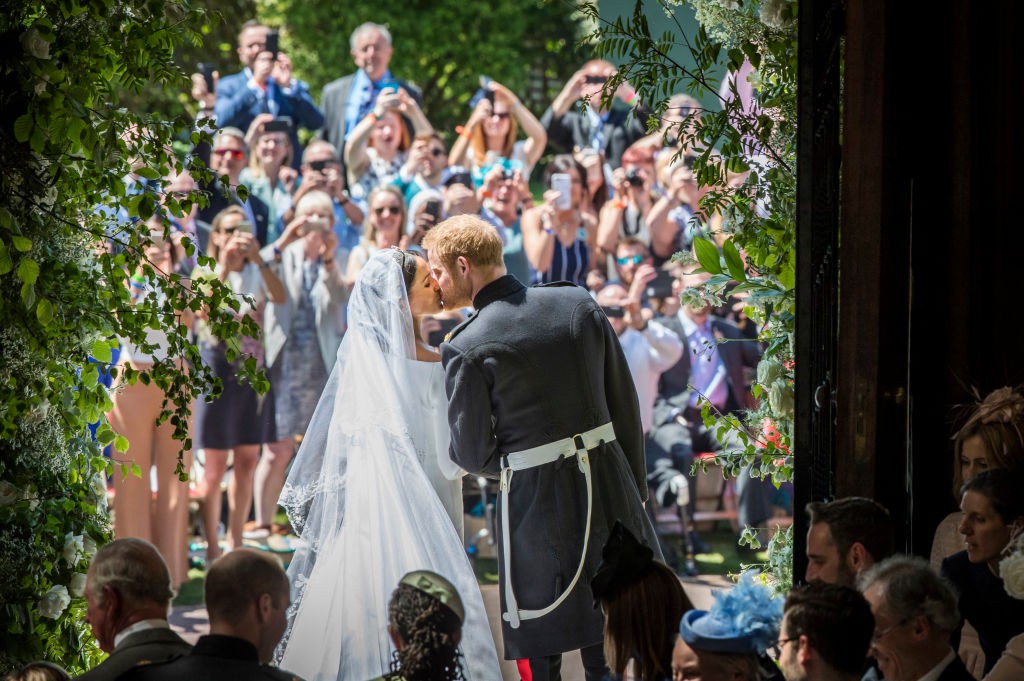 WINDSOR, UNITED KINGDOM - MAY 19: Prince Harry and Meghan Markle kiss on the steps of St George's Chapel in Windsor Castle after their wedding in St George's Chapel at Windsor Castle on May 19, 2018 in Windsor, England. (Photo by Danny Lawson - WPA Pool/Getty Images)